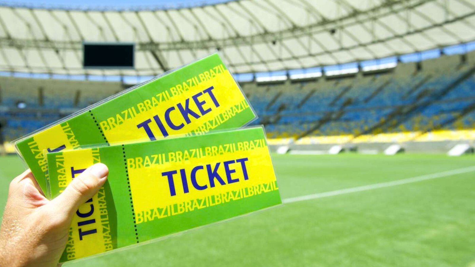 A man holding football tickets in hand